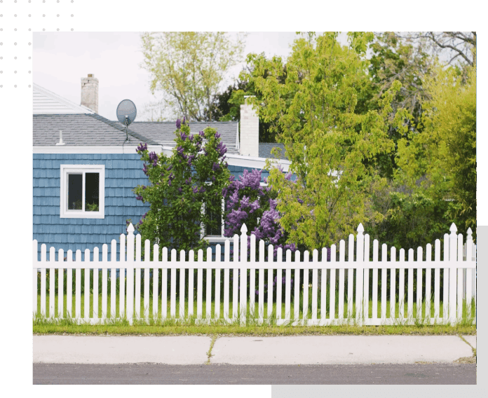 A house with a fence and trees in the background