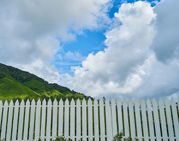 A white fence with mountains in the background