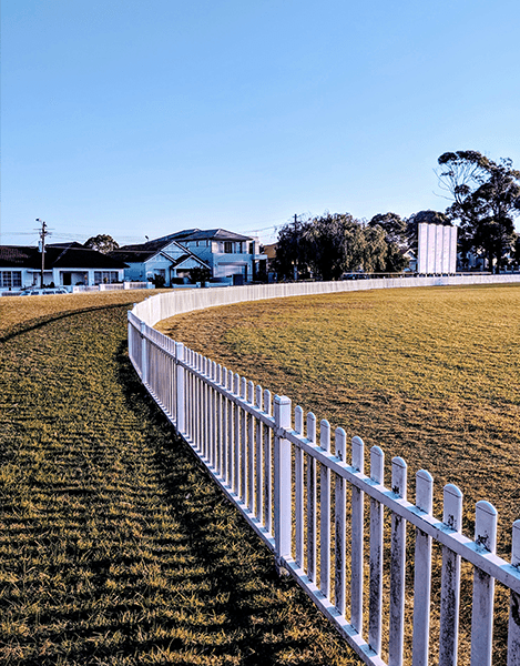 A fence is shown in front of a field.